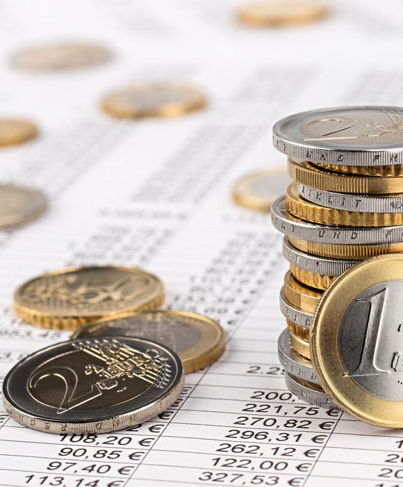 Finanzwesen, Buchhaltung, Aktienhintergrund mit einem Stapel Euro-Münzen auf einem Datenblatt